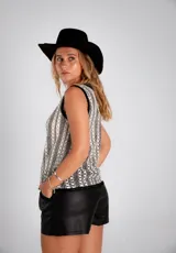 Musculosa de tejido calado color blanco y negro, con cuello redondo y terminaciones en crochet.