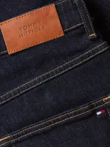 Pantalón de jeans azul oscuro, de corte recto, con bolsillos delanteros y traseros, y costuras en hilo amarillo.