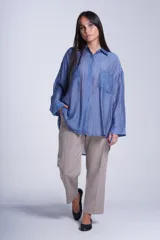 Camisa negra de tela traslúcida con cuello clásico, cierre frontal con botones y dos bolsillos de parche en el pecho.