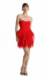Vestido corto rojo con escote strapless y falda con volados de organza transparente.