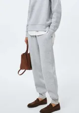 Pantalón deportivo de felpa color gris melange, de corte relajado, con cintura elástica y puños en los tobillos.