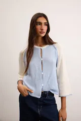 Saco de algodón tejido, color beige con mangas y detalles en blanco, escote en V y cierre frontal de botones.