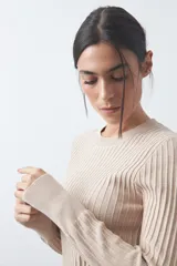 Sweater de tejido tipo rib, color negro, con cuello redondo y mangas largas. Presenta una textura acanalada y un ajuste al cuerpo.