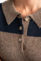 Sweater de punto con cuello polo y cierre frontal de tres botones. Presenta un diseño de corte oversize, mangas largas y textura acanalada.