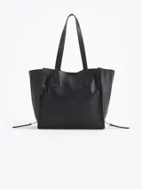 Bolso tipo tote de cuero color tostado con doble asa de hombro, detalles de hebillas metálicas en el frente y cierres laterales decorativos.