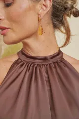 Caravanas colgantes doradas con diseño de gota y piedra facetada en tono amarillo ámbar.