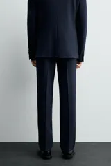 Pantalón de vestir de corte slim fit, confeccionado en tejido con viscosa. Presenta bolsillos frontales, bolsillos traseros de doble vivo con botón y cierre frontal con cremallera y botón.