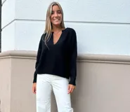 Buzo de punto negro, con escote en V pronunciado, mangas largas y corte holgado.