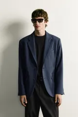 Blazer regular fit azul marino confeccionado en tejido con elasticidad, con cuello de solapas de muesca, cierre frontal con botones y bolsillos con solapa en la cadera.