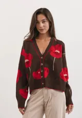 Cardigan de punto color chocolate con estampado de flores rojas, escote en V, cierre frontal con botones y puños y ruedo acanalados.