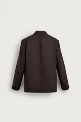 Blazer de corte relaxed fit color marrón, confeccionada en tejido con mezcla de lana. Presenta cuello con solapas de muesca, manga larga, bolsillos de vivo en la cadera y cierre frontal de botonadura con dos botones. Cuenta con forro interior combinado a contraste y abertura en el centro de la espalda.