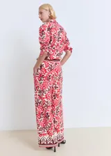 Pantalón largo de corte recto y tejido fluido, con estampado paisley en tonos rojo, bordó y crudo. Cuenta con cintura elástica con cordón ajustable y bolsillos laterales.