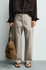 Pantalón relaxed fit para hombre, confeccionado en tejido con mezcla de algodón y lino, en color beige. Presenta bolsillos laterales, bolsillos traseros de plastrón y cierre frontal con cremallera y botón.