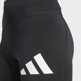Calza deportiva ajustada al cuerpo, color negro, tiro alto, con el logo de Adidas en forma de tres barras blancas en el muslo izquierdo.