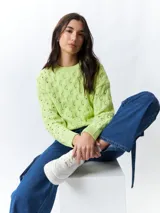 Sweater color crema tramado de manga larga y cuello redondo.