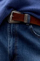 Cinturón de cuero color tostado con hebilla metálica plateada de estilo western con detalles grabados.