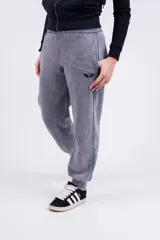 Pantalón de jogging gris con efecto lavado, corte holgado y logo bordado en negro.
