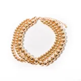 Gargantilla dorada de tres hilos con cuentas de diferentes tamaños.