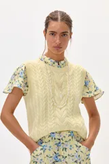 Chaleco amarillo de hilo con diseño trenzado.