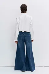 Blusa celeste de manga larga con puños fruncidos y elásticos, escote en V con cuello alto con volados y delicados bordados florales en el pecho.