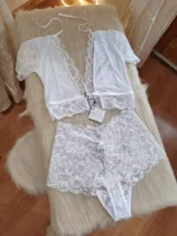 Conjunto de lencería compuesto por un top de encaje con mangas cortas y escote profundo, y una bombacha tipo hipster de encaje completo.