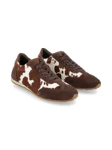 Championes de diseño urbano con paneles combinados en gamuza marrón y pelo sintético con estampado de vaca en tonos marrón y blanco. Presenta cierre con cordones al tono y suela de goma plana.