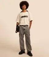 Pantalón de jean gris con efecto acid wash, modelo baggy de corte ancho, cintura con trabillas y bolsillos cargo en los laterales.