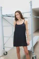 Vestido corto negro de satén, con breteles finos regulables, espalda cavada y corte amplio tipo A.