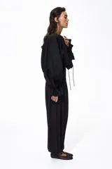 Pantalón negro de tiro alto confeccionado en punto interlock pesado. Cuenta con cintura elástica con pliegues cosidos alrededor, diseño de piernas barrel y puños elásticos ceñidos en los tobillos.