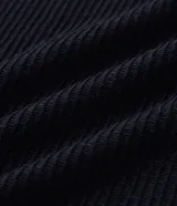 Polo de manga larga color beige claro, confeccionado en tejido texturizado (posiblemente acanalado o waffle). Presenta un cuello polo con escote profundo en V sin botones.