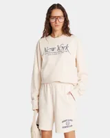 Short color crema de jersey grueso, largo medio, con cintura con cordón, bolsillos delanteros y un bolsillo trasero. Estampado frontal con el logo de la marca.