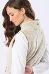Chaleco de tejido sherpa color beige, con cuello alto y detalles en eco cuero. Diseño sin mangas que proporciona abrigo al torso manteniendo la libertad de movimiento.