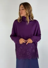 Sweater color beige con cuello alto y detalle de encaje en el frente.