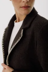 Blazer color verde oscuro con solapas con pespuntes blancos, de corte recto y cierre con un botón.