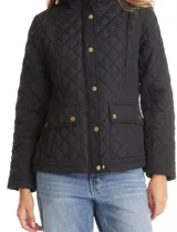 Campera capitoneada color beige con diseño de rombos, cuello alto tipo mao, cierre frontal con cremallera y solapa con botones a presión dorados. Cuenta con dos bolsillos frontales de parche con solapa y botones.
