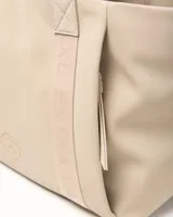 Cartera tote color taupe de símil cuero con tiras de hombro estampadas con la marca y detalle de logo circular en el frente.