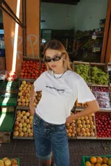 Remera blanca de manga corta con cuello redondo y texto estampado en negro en el pecho que dice "ME GUSTAS MUCHO. (ups)".