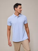 Chomba celeste de piqué de algodón, corte clásico, cuello polo con botones y logo bordado en el pecho.