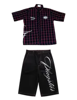 Conjunto compuesto por una camisa de manga corta a cuadros rojos y negros con detalles gráficos bordados y un short negro de corte holgado con costuras en contraste y estampa lateral con tipografía cursiva.