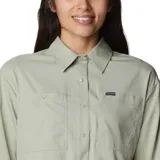 Camisa de manga larga Columbia, color verde claro, con cuello clásico, cierre frontal de botones y dos bolsillos frontales en el pecho. Presenta un diseño funcional con ventilación y tecnología de protección solar.
