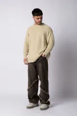 Sweater de tejido grueso con cuello redondo, mangas largas con puños acanalados y corte relajado.