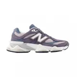Championes urbanos New Balance modelo 9060, con diseño robusto y futurista en tonos violeta, gris y blanco. Presentan una combinación de materiales en gamuza y malla, con el logo N característico en los laterales y una suela gruesa con tecnología de amortiguación.