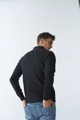 Campera negra de algodón con cierre completo, cuello alto, bolsillos laterales, puños y logo bordado en el pecho.