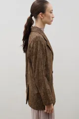 Blazer de lana con diseño bicolor, cuerpo en color negro y mangas en color crema. Presenta un corte holgado, cierre cruzado con doble botonadura y solapas amplias en contraste.