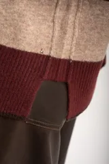 Sweater de punto con diseño de rayas horizontales anchas en color bordó y beige. Presenta cuello redondo con detalle de lurex, mangas largas y puños y ruedo acanalados.