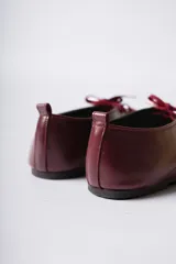 Zapato acordonado de cuero color negro, de diseño minimalista con punta cuadrada y silueta moderna.