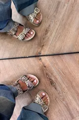 Sandalias con estampado de reptil, confeccionadas 100% en cuero, con plantilla de cuero y hebillas doradas.