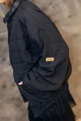 Campera puffer de diseño matelaseado en rombos, color beige. Presenta cuello alto, cierre frontal y solapa triangular decorativa con logo bordado. Posee mangas largas con puños elastizados y ruedo ajustado tipo bomber.