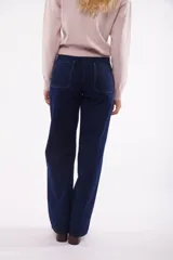 Pantalón de jean azul medio, corte wide leg, con bolsillos delanteros tipo parche y tiro alto.