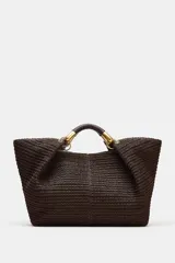 Maxi bolso color marrón con efecto rafia, doble asa de mano rígida con detalles metálicos dorados y cierre con botón imantado.